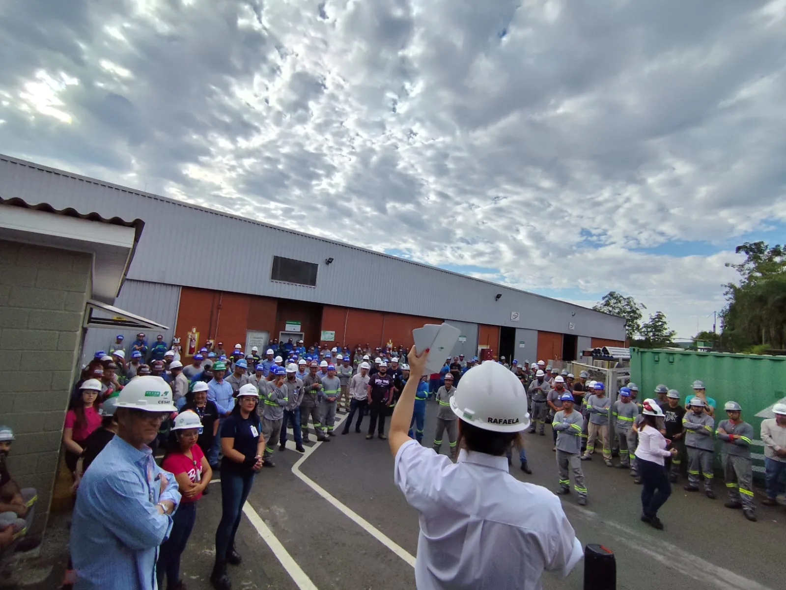 Raffa conduzindo uma palestra ao ar livre para uma equipe de operação com capacetes