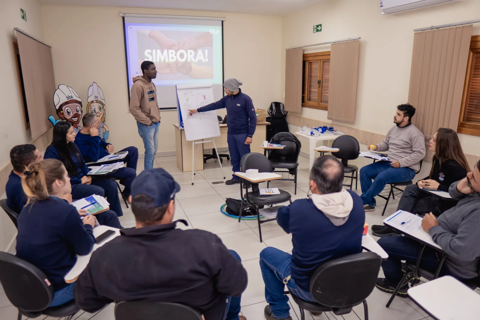 Grupo de trabalho interdisciplinar reunido em sala diante do flip chart
