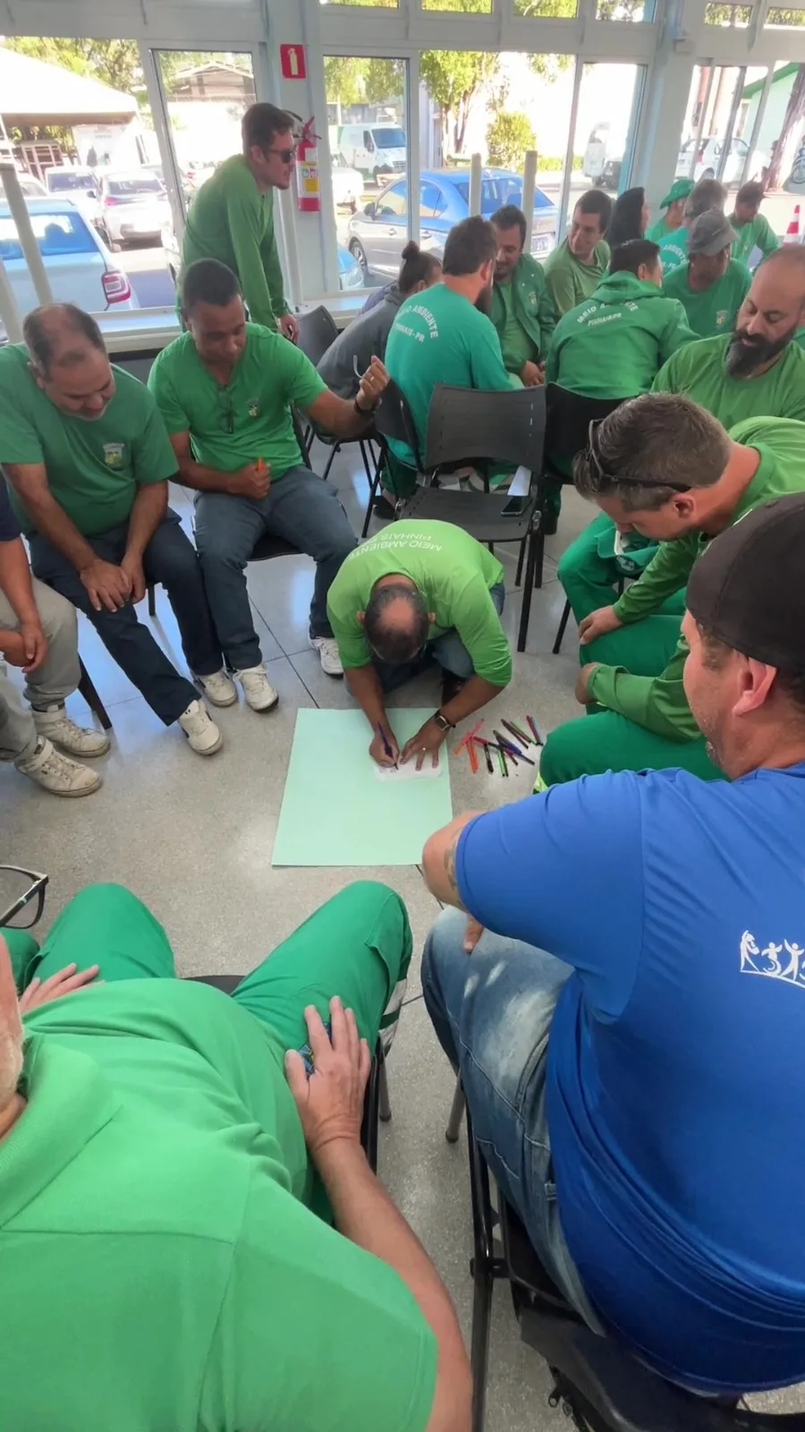 Equipe de operação realizando uma dinâmica no chão do galpão