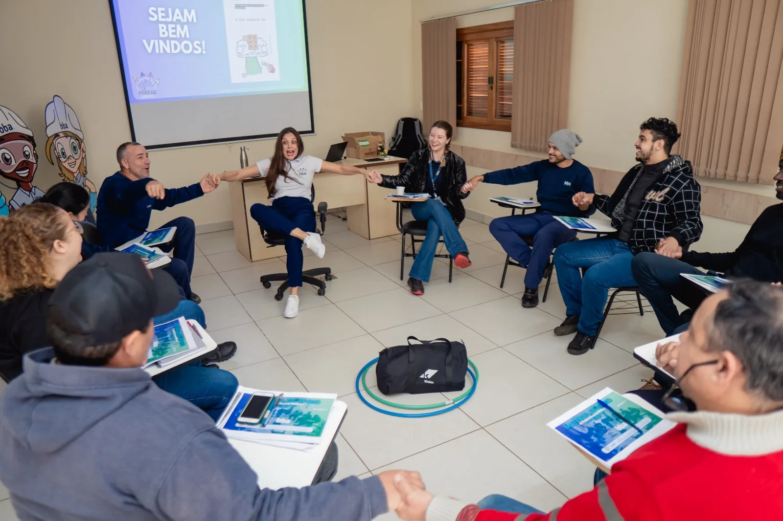 Participantes em roda, com materiais no centro, durante um treinamento