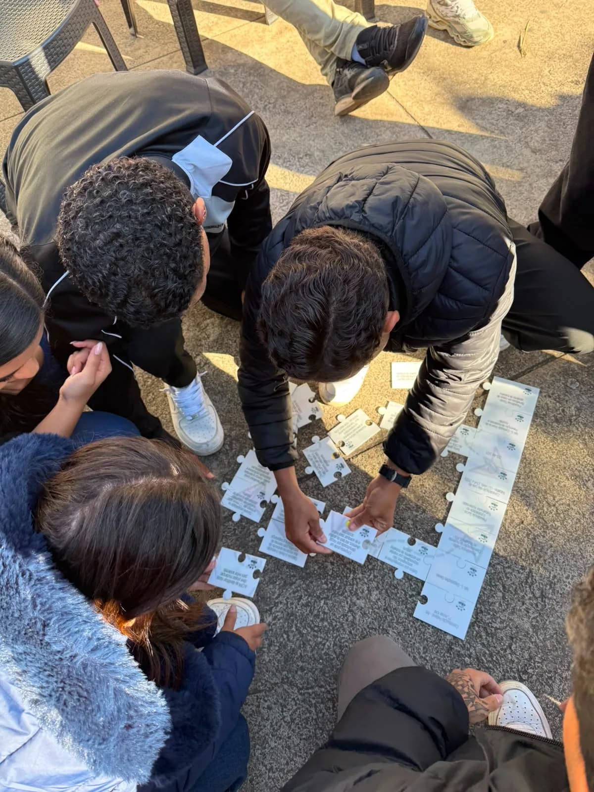 Participantes montando um quebra-cabeça no chão durante um treinamento