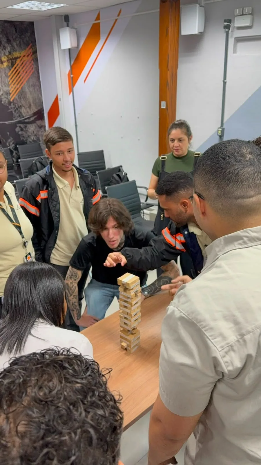 Participantes em volta de uma torre de blocos durante um treinamento